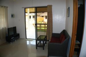 uma sala de estar com uma cadeira e uma televisão em Panglao Homes Resort & Villas em Panglao