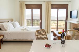 Habitación de hotel con 1 cama y 2 mesas con copas de vino en Dictamus Homes, en Magoulás