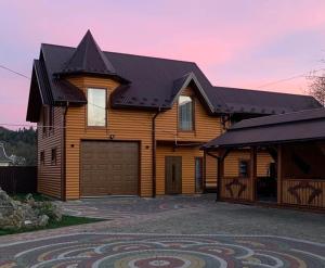 a large wooden house with a garage at Садиба Надія in Sheshory