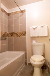 a bathroom with a white toilet and a bath tub at Sis Q Inn in Weed