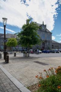 a large building with a clock tower on a street at Flor du Mont Gîte in Pontorson