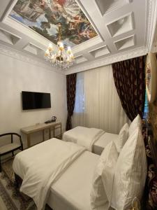 a hotel room with two beds and a ceiling at Nabat Palace Arbat in Moscow