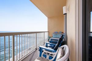 balkon z niebieskimi krzesłami i widokiem na ocean w obiekcie Calypso Resort 2 w mieście Panama City Beach