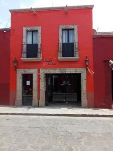 a red building with two windows and two doors at Hotel Santa Ana in San Miguel de Allende