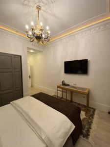 Un dormitorio con una cama grande y una lámpara de araña. en Nabat Palace Arbat, en Moscú