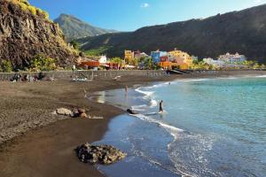 a beach with a group of people in the water at Apartamento en el Centro de Tazacorte in Tazacorte