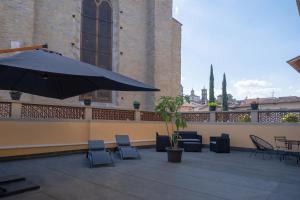 un patio con sedie e ombrellone su un balcone di Città Di Castello Rooms a Città di Castello