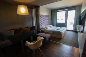 um quarto de hotel com uma cama, uma mesa e cadeiras em VISION APARTMAN em Sárvár