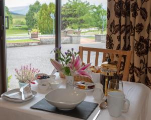 a table with a plate of food and a window at Springburn Farmhouse in Spean Bridge