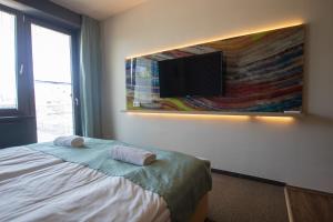 um quarto com uma cama e uma televisão de ecrã plano em VISION APARTMAN em Sárvár