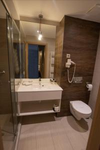 La salle de bains est pourvue d'un lavabo et de toilettes. dans l'établissement VISION APARTMAN, à Sárvár