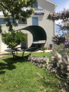 a bench in the grass in front of a building at Apartments Kristal in Kaštela