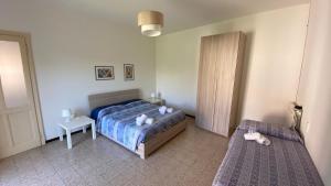 ein Schlafzimmer mit einem Bett und einem Nachttisch sowie einem Bett und einem Bettrock in der Unterkunft Villa Vanda in Castelveccana