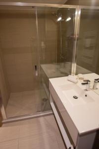 a bathroom with a shower and a white sink at VISION APARTMAN in Sárvár