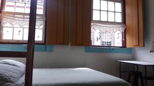 a bedroom with a bunk bed and two windows at Hostel Imperial in Ouro Preto