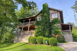 a house covered in ivy with a yard at Spacious Gatlinburg Cabin with Hot Tub and Game Room! in Gatlinburg