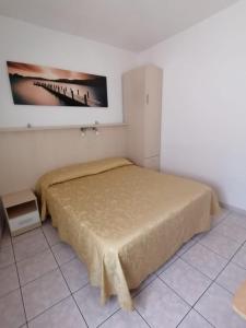 a bedroom with a bed and a picture on the wall at Camere la torre in Volterra