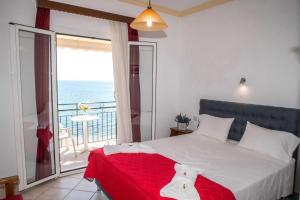 1 dormitorio con 1 cama y balcón con vistas al océano en Empress Corfu, en Perama