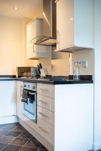 a kitchen with white cabinets and a stove top oven at No18 Nursery Convent in Mansfield