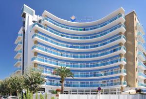 a tall white building with blue windows at GHT Maritim in Calella