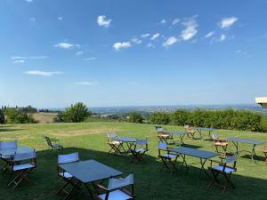 a group of tables and chairs on a field at R&B Del Monte in Forlì