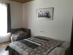 um quarto com uma cama e uma fotografia na parede em Balatonkenesei Vendégház em Balatonkenese