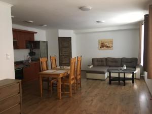 a kitchen and a living room with a table and a couch at Balatonkenesei Vendégház in Balatonkenese