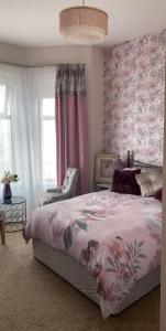 a bedroom with a bed and a pink floral wall at Conlyn house in Newcastle