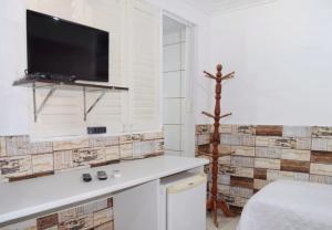 Zimmer mit einem Wand-TV und einem Bett in der Unterkunft Pousada Recanto do Amanhecer in Porto De Galinhas