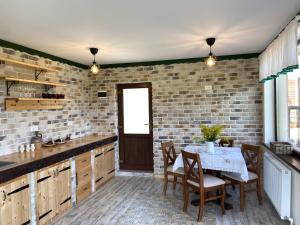 a kitchen with a table and a brick wall at Căsuța Top House in Zărneşti