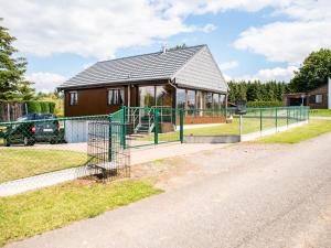 ein kleines Haus mit einem Zaun drum herum in der Unterkunft Alluring Holiday Home in Fraiture with Infrared Sauna in Fraiture