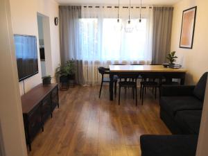 salon i jadalnia ze stołem i telewizorem w obiekcie Apartament przy Starówce w mieście Sandomierz