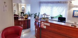 a waiting room with a desk and a red chair at Willa-Restauracja Victoria in Ostrowiec Świętokrzyski