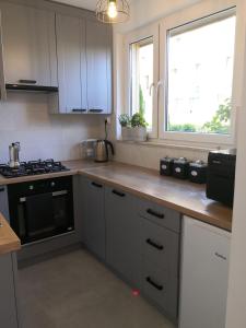 a kitchen with white cabinets and a stove and a window at Apartament przy Starówce in Sandomierz