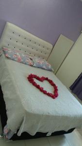 a heart made out of flowers on a bed at Hospedaria Casa de Maria in Angra dos Reis