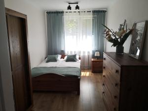 sypialnia z łóżkiem, oknem i komodą w obiekcie Apartament przy Starówce w mieście Sandomierz