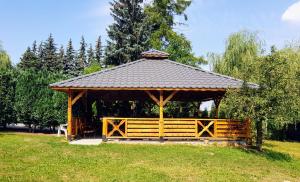 un cenador de madera con techo en un campo en Willa-Restauracja Victoria en Ostrowiec Świętokrzyski