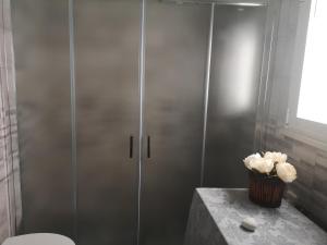 a shower stall with a toilet and a vase of flowers at Casa Vacanza Taviano in Taviano +82 photos