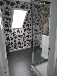 a bathroom with a glass shower stall with a window at The Old Endie Hoose Kirkwall Orkney in Kirkwall