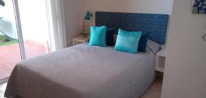 a bedroom with a bed with blue pillows at Apartamento Pardela in Adeje