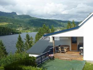 a house with a deck with a view of a lake at Four-Bedroom Holiday home in Bygstad 1 in Bygstad