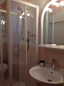 y baño con ducha, lavamanos y ducha. en Hotel I Pionieri, en Abetone