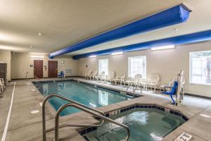 a swimming pool with chairs and tables in a building at Cobblestone Hotel & Suites - Erie in Erie