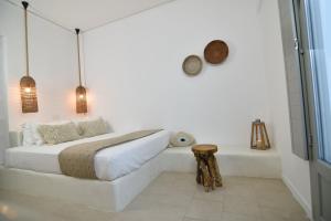 um quarto branco com uma cama e uma banheira em Aegeeis em Perissa mais 37 fotografias