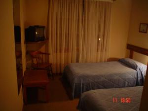 Habitación de hotel con 2 camas y TV en La Posada B&B en Esquel