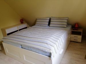 ein Bett mit gestreifter Bettwäsche und Kissen in einem Schlafzimmer in der Unterkunft Haus Bernsteinchen in Gustow