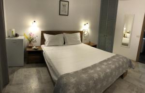 ein Schlafzimmer mit einem großen Bett und einem Kühlschrank in der Unterkunft Vila Blanc in Costinești