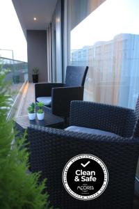 a group of wicker chairs and tables on a balcony at Casa do Kiko in Ponta Delgada