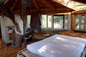 um quarto com uma cama grande e uma árvore em Margaritis's Treehouse em Paramonas