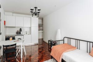 ポルトにあるESM Rental - Santa Catarina Cozy Apartmentのキッチン、リビングルーム(ベッド1台、テーブル付)